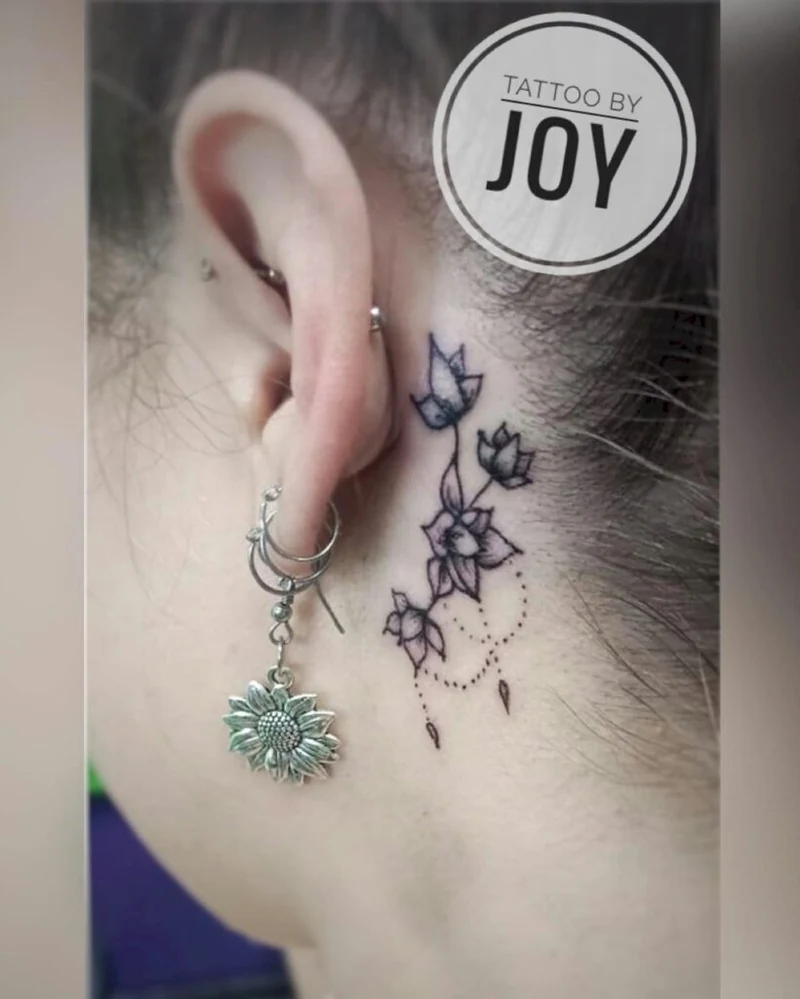 Student work: fine floral tattoo behind an ear