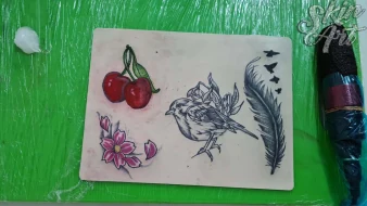Cherries, flowers and feather tattoo exercises on synthetic skin