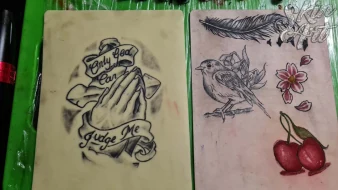 Lettering, flowers and feather tattoo practice on synthetic skin