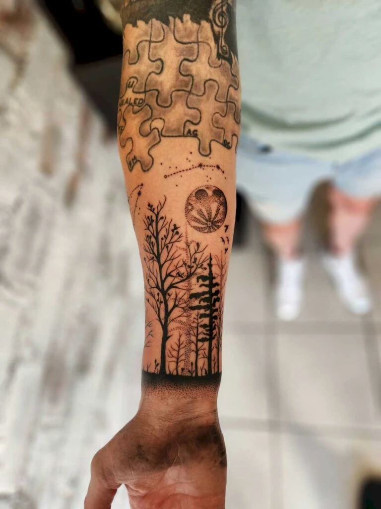 Student work: puzzle pieces and forest tattoo on a forearm