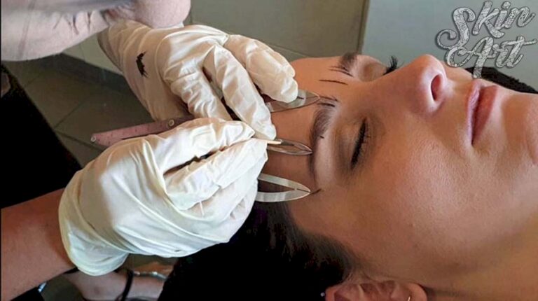 Gloved hands using a handheld tool along an eyebrow